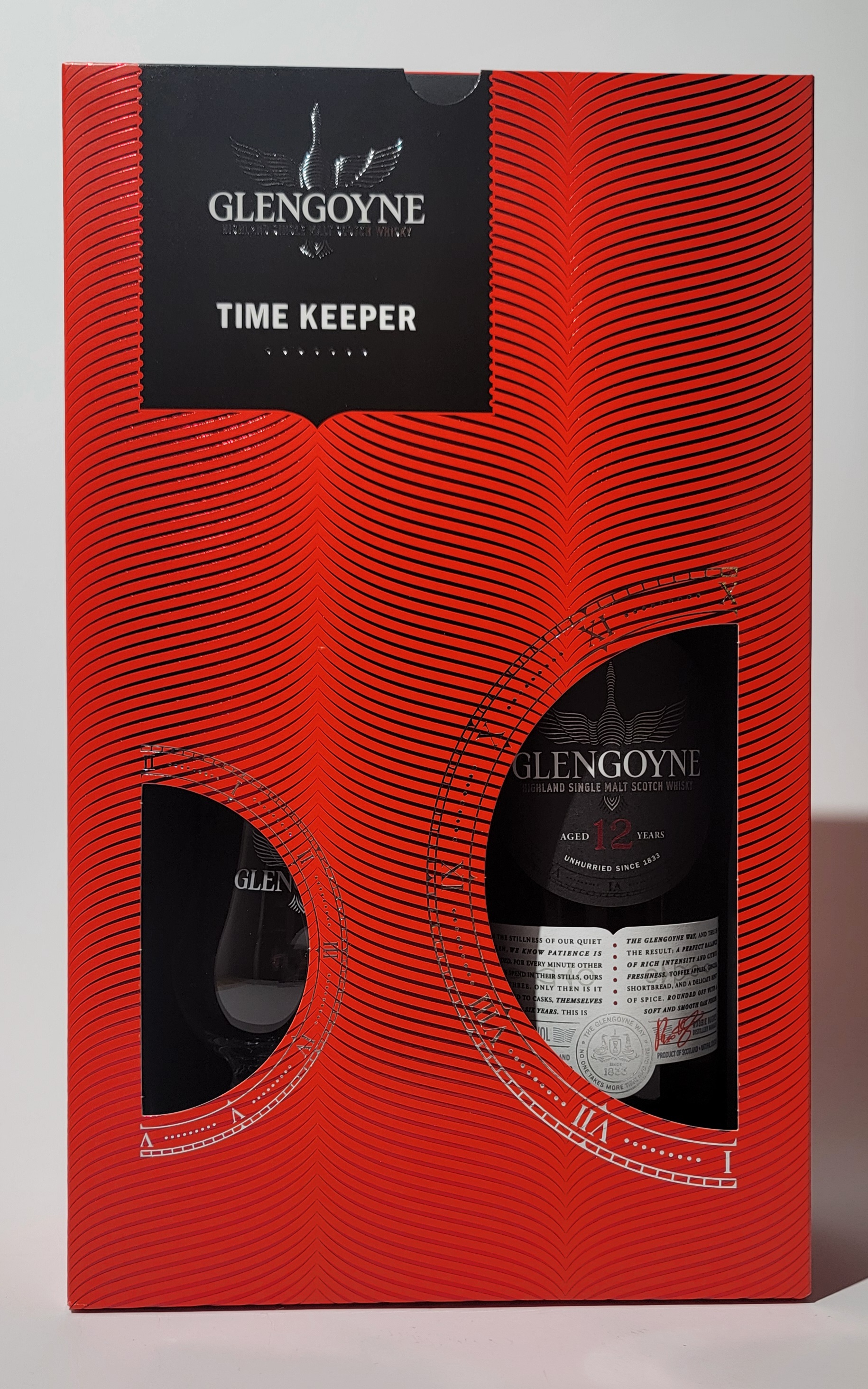 Geschenksverpackung in rot mit zwei Sichtfenster auf die Flasche (rechts) und das Glas (links)