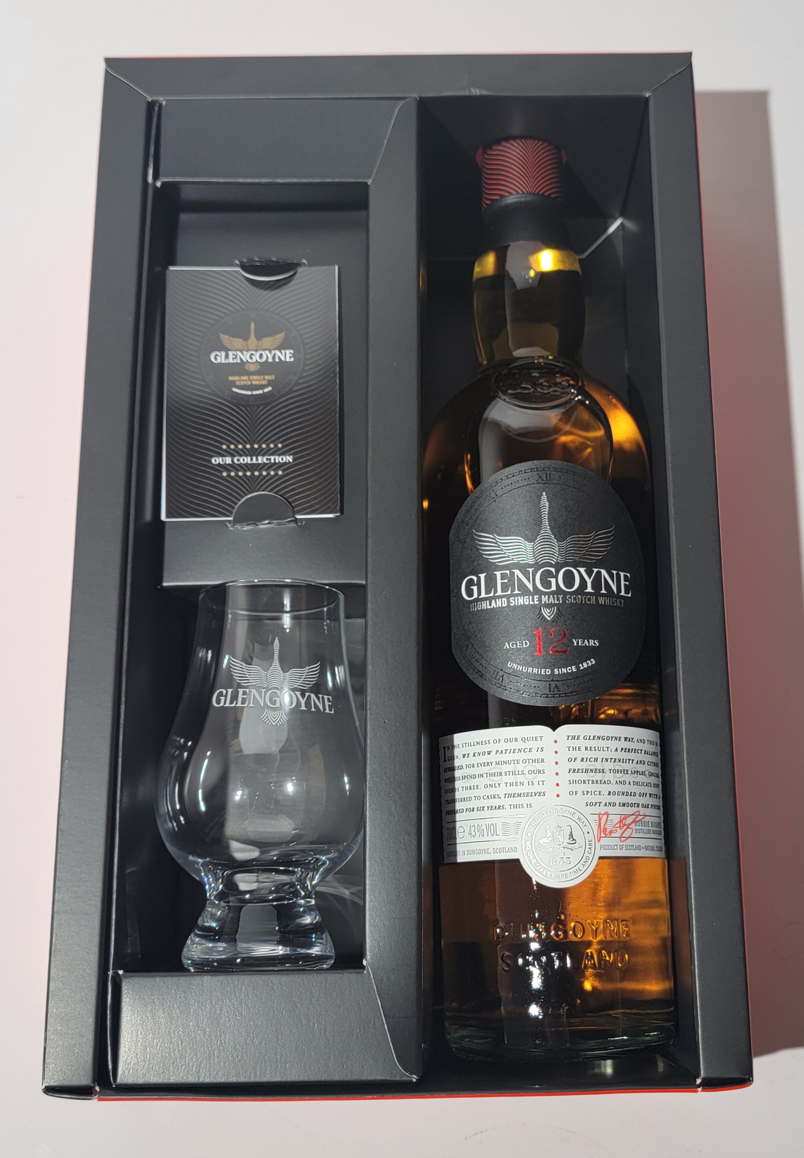 Geöffnete Geschenksverpackung mit der Flasche und einem Glas in der Verpackung