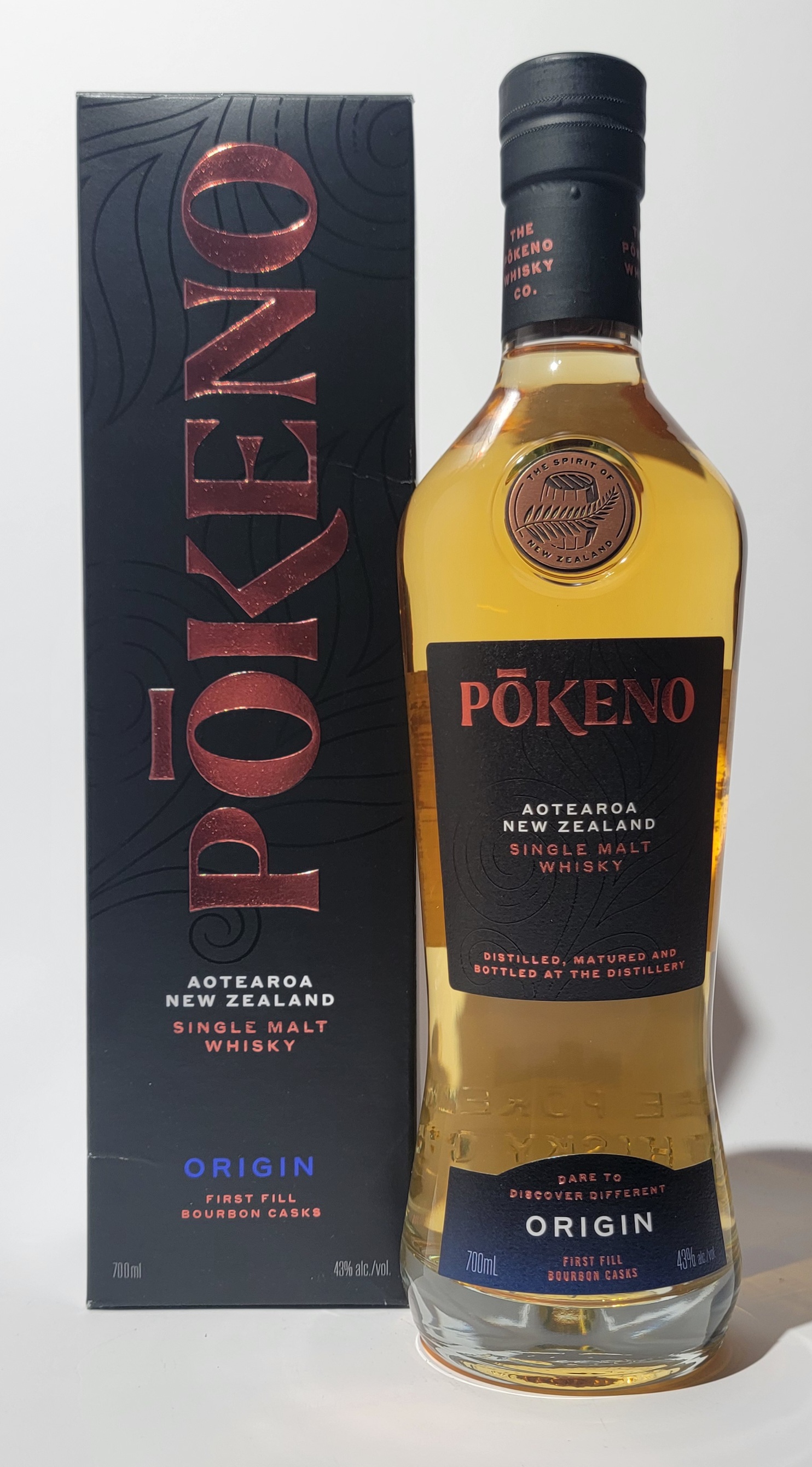 Flasche neben Verpackungskarton - Pokeno Origin